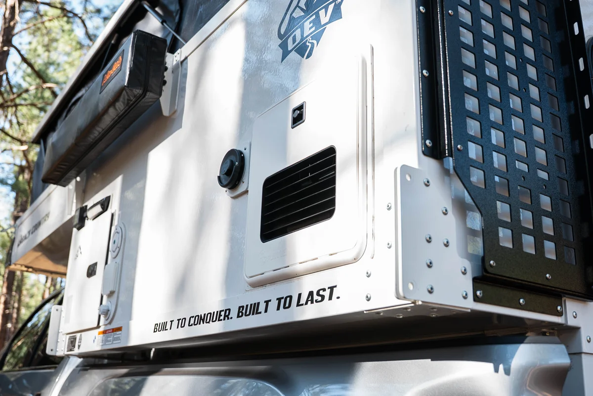 Back Country 6.85 exterior wall detail showing Truma heater vent and 'Built to Conquer. Built to Last.' decal
