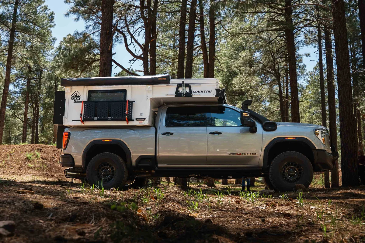 Back Country 6.85 full driver-side profile on GMC AT4X HD with pop-up roof deployed in pine forest