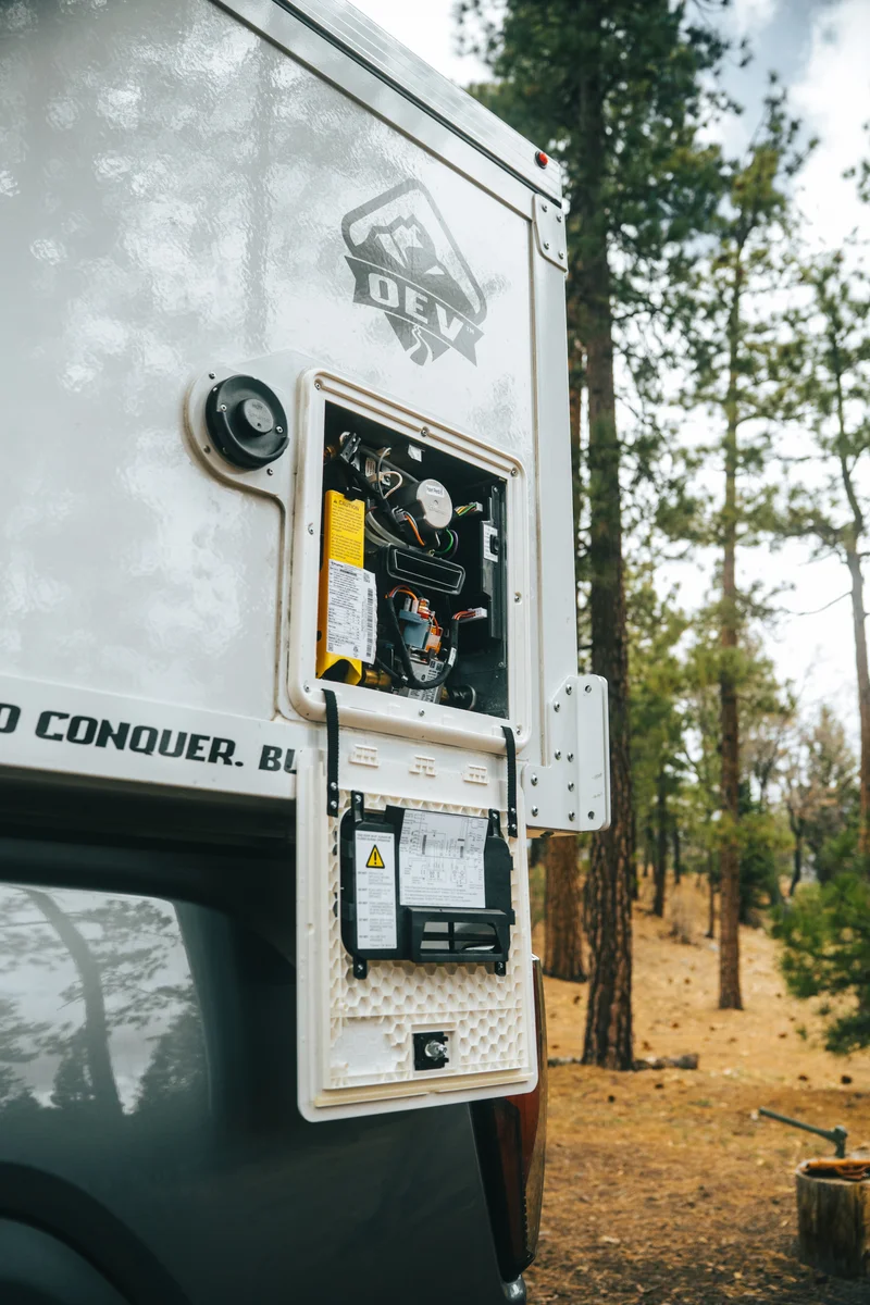 Back Country 6.85 exterior utility panel open showing Truma VarioHeat heater components