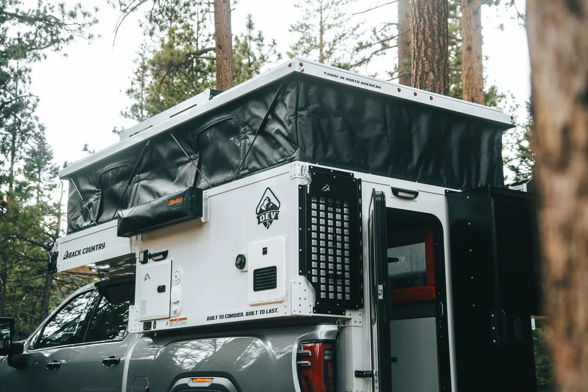Back Country 6.85 driver side with pop-up soft walls raised, Back Country badge, and 'Built to Conquer' visible