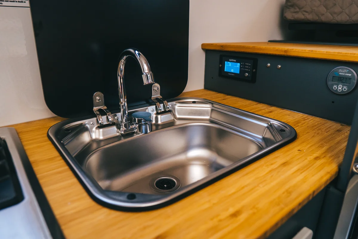 Back Country 6.85 stainless sink with faucet and Xantrex Freedom X inverter display and Victron monitor visible
