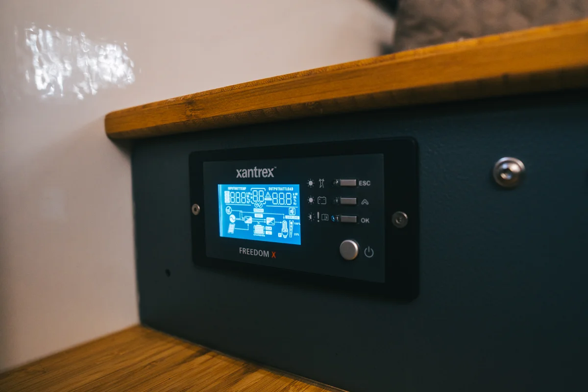 Back Country 6.85 Xantrex Freedom X inverter display panel close-up with lit blue screen