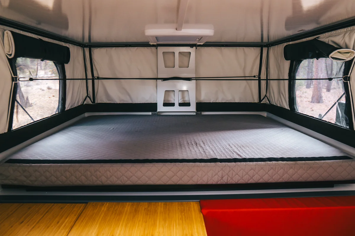Back Country 6.85 queen mattress sleeping area with pop-up soft walls deployed and windows on both sides