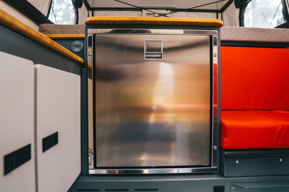 Back Country 6.85 Dometic compressor fridge stainless door closed between cabinetry and red dinette