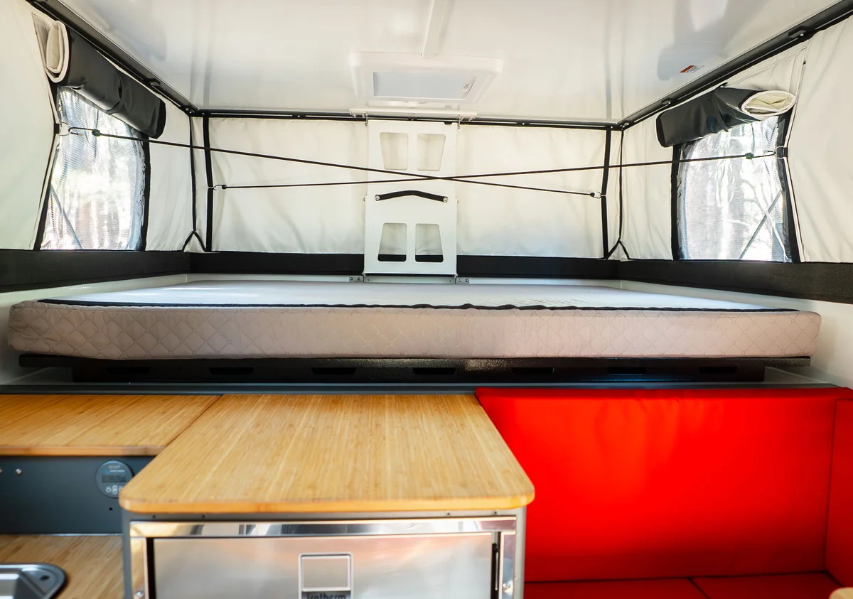 Back Country 6.85 sleeping area with the queen mattress and the pop-up roof fully extended