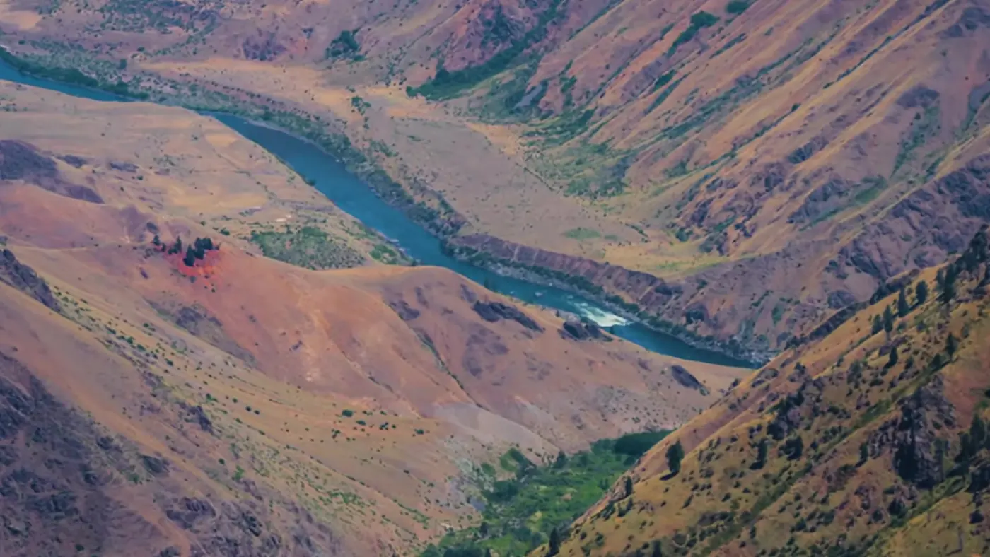 The Snake River winding through the red and green walls of Hells Canyon, seen from high above in the Hat Point section of Zero Declination's video